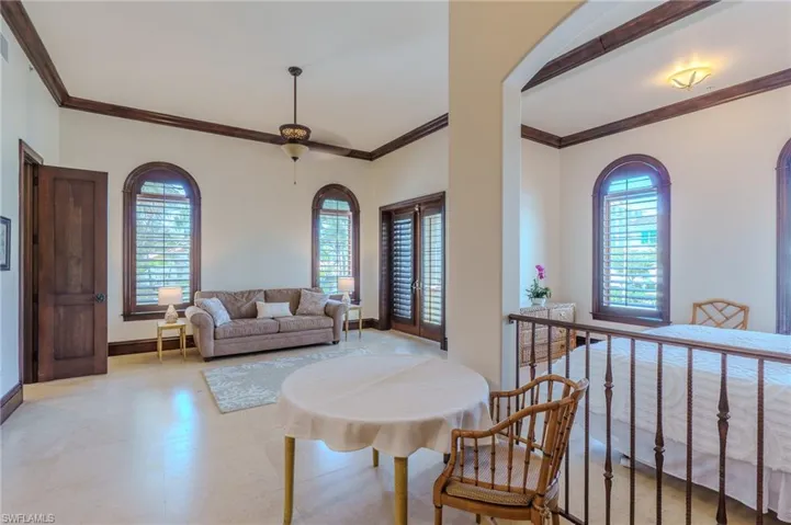 Living area featuring ornamental molding and light floors