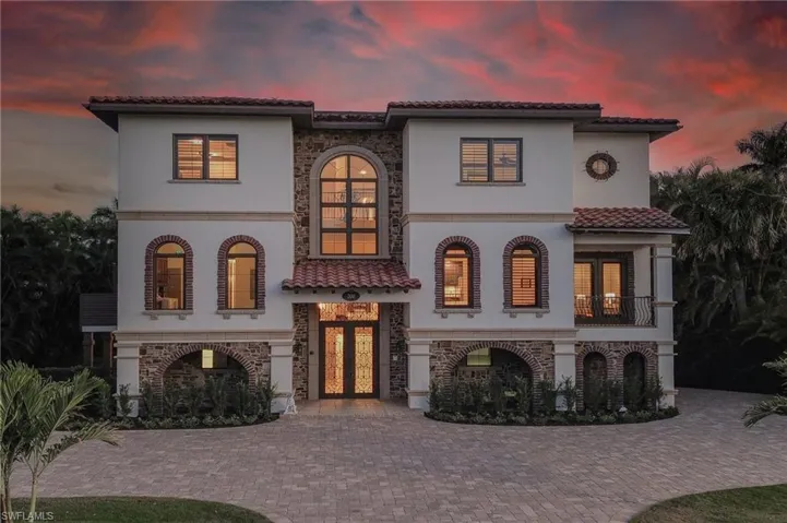 Mediterranean / spanish home featuring french doors, stone siding, stucco siding, a balcony, and a tiled roof