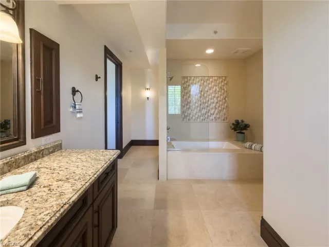 Full bathroom with vanity, a bath, a tile shower, and recessed lighting