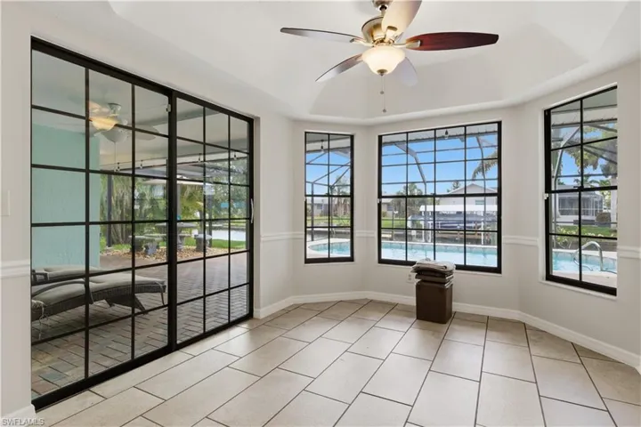 Interior space featuring large-format tile flooring, a tray ceiling, and a ceiling fan