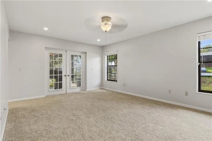 Light-colored wall-to-wall carpeting complements the neutral wall tones