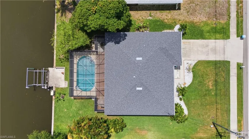 Overhead property perspective featuring a screened pool, private boat dock with lift, and direct water access