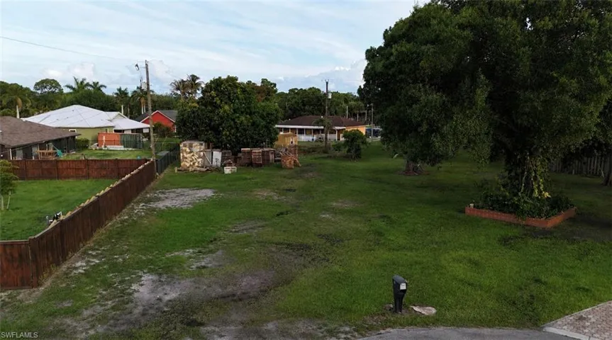 Expansive green space featuring mature trees and partial fencing