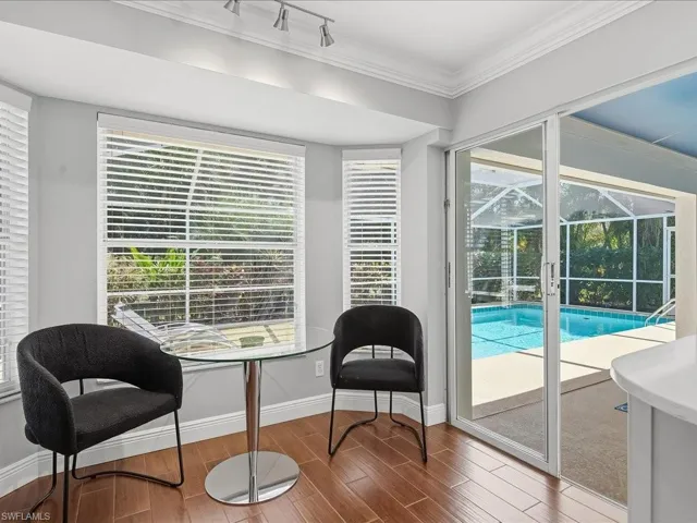 Sitting room featuring wood tiled floors, crown molding, a sunroom, and track lighting