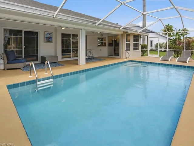 Swimming pool with glass enclosure, a sunroom, and a patio