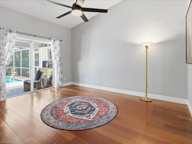 Unfurnished room featuring vaulted ceiling, a ceiling fan, and wood finished floors