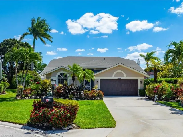 Ranch-style home with an attached garage, concrete driveway, a front lawn, and stucco siding