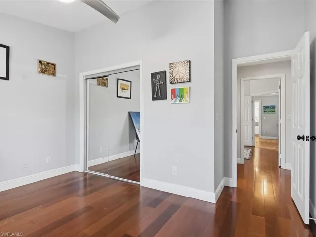 Unfurnished bedroom with dark wood-type flooring and a closet