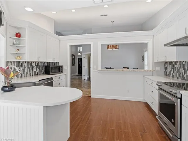 Kitchen featuring tasteful backsplash, stainless steel appliances, open shelves, white cabinetry, and recessed lighting