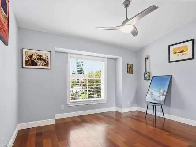 Unfurnished room featuring ceiling fan and dark wood finished floors