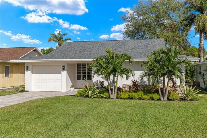 View of front of house featuring a front lawn and a garage