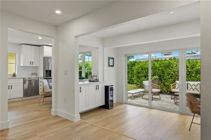 Kitchen featuring stainless steel appliances, plenty of natural light, white cabinets, and wine cooler
