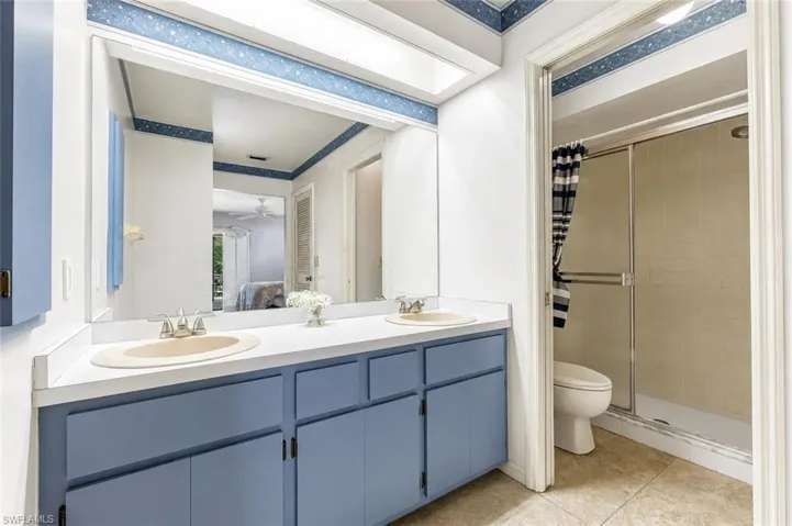 Dual basin vanity with white countertop and blue cabinetry