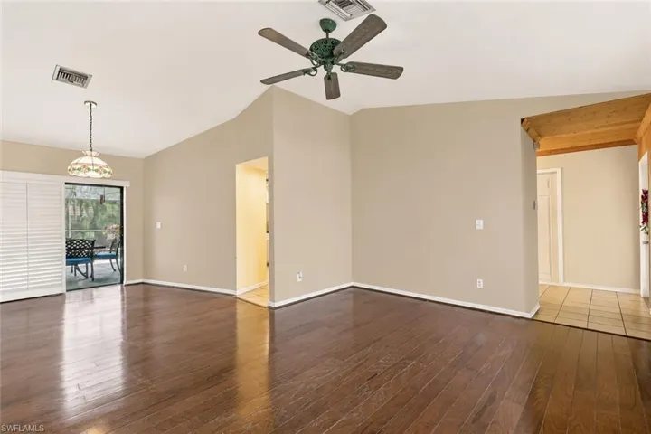 Spacious interior featuring wood-finish flooring, vaulted ceilings, and a ceiling fan