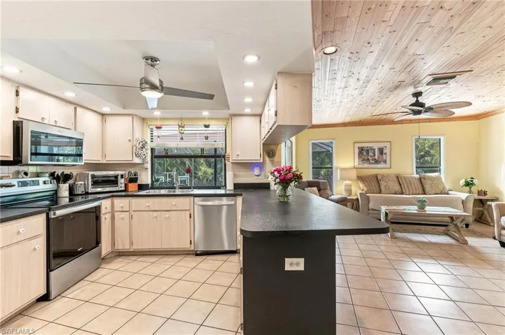 Kitchen featuring light wood-finish cabinetry, dark countertops, and stainless steel appliances.