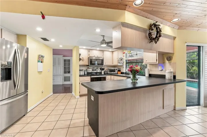 Kitchen featuring wood-finish cabinetry, dark countertops, and stainless steel appliances