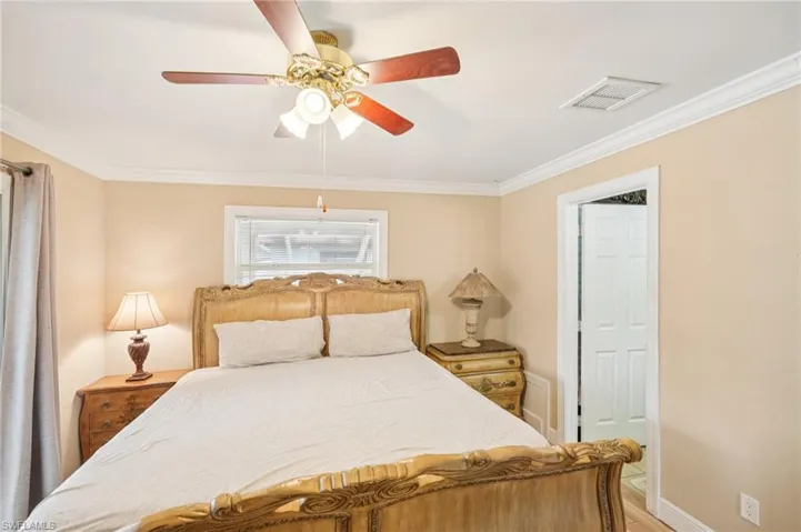 Bedroom featuring crown molding, a ceiling fan, and light wood-type flooring