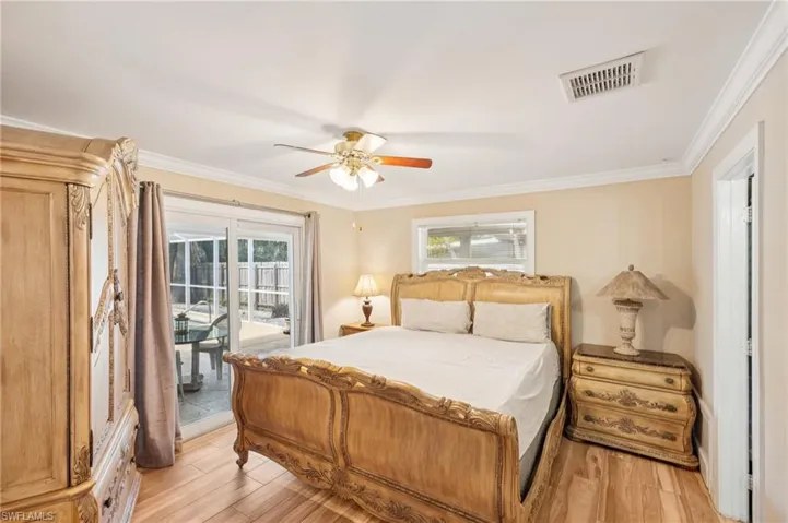 Bedroom with light wood-style flooring, multiple windows, crown molding, ceiling fan, and access to exterior