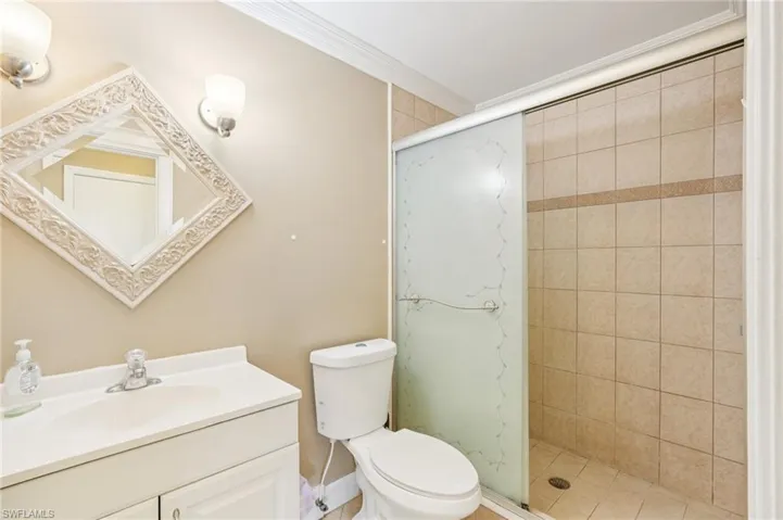 Full bath with vanity, a stall shower, and ornamental molding