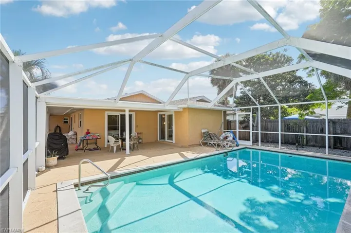 View of pool with a sunroom, a lanai, and patio surround