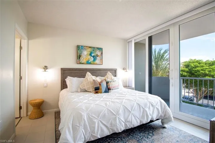 Bedroom featuring access to exterior, tile patterned floors, a textured ceiling, and floor to ceiling windows