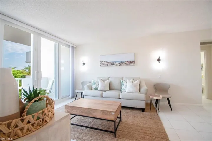 Tiled living room featuring a textured ceiling and a wall of windows