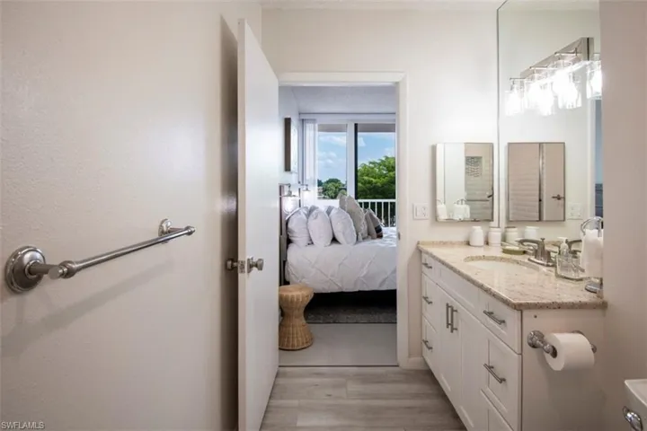 Bathroom featuring vanity, light wood-style flooring, and ensuite bath
