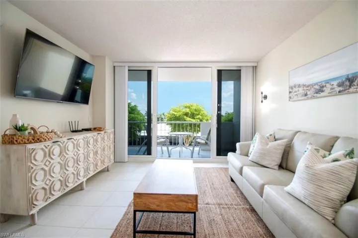 Tiled living area with a wall of windows and a textured ceiling