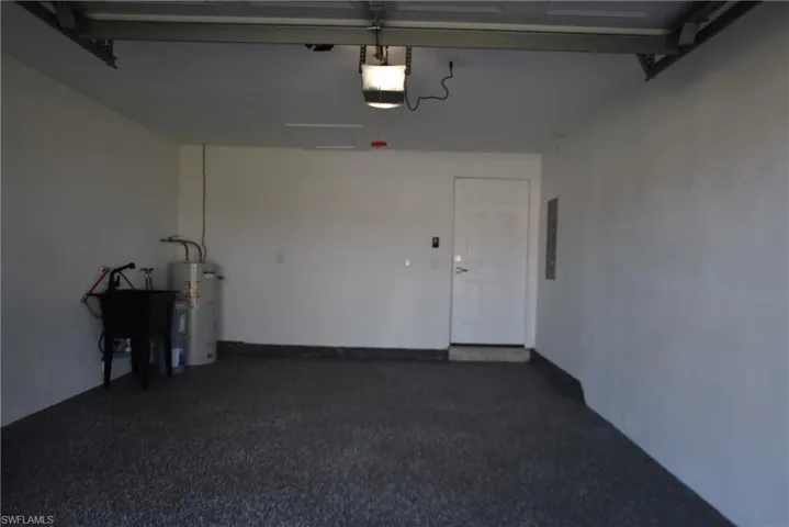 Garage with secured water heater, a garage door opener, and electric panel