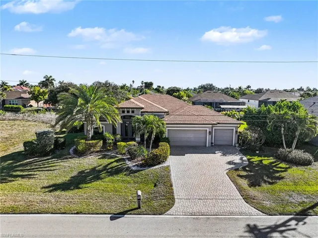View of front facade featuring a front lawn, decorative driveway, an attached garage, and a residential view