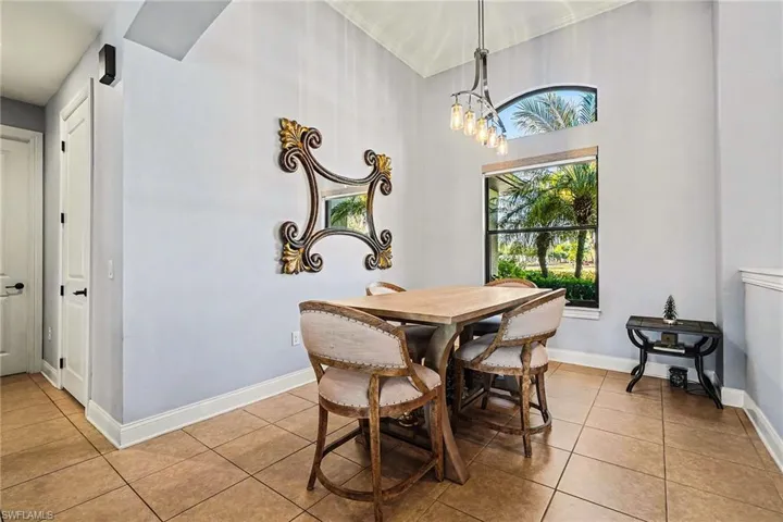 Dining space featuring light tile patterned flooring and a high ceiling