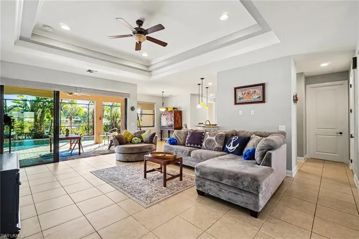 Living area featuring a ceiling fan, light tile patterned floors, recessed lighting, and crown molding