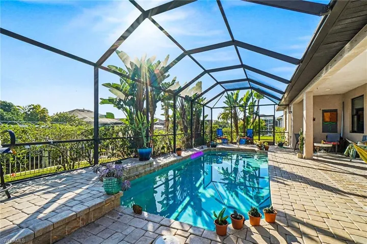 Swimming pool with a sunroom, glass enclosure, and a patio