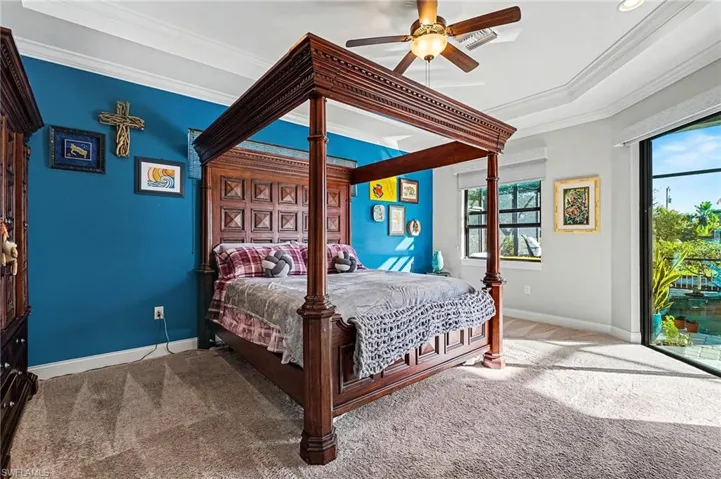 Carpeted Master bedroom featuring ceiling fan and ornamental molding