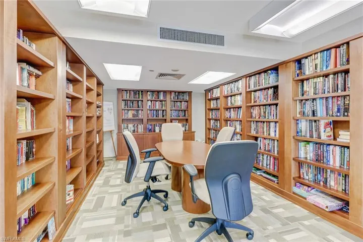 Office space featuring bookshelves and light colored carpet