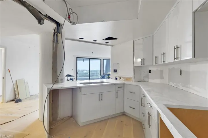 Kitchen featuring white cabinetry, light wood-type flooring, a peninsula, and black electric cooktop
