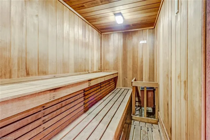 Sauna featuring wood walls, wooden ceiling, and wood-type flooring