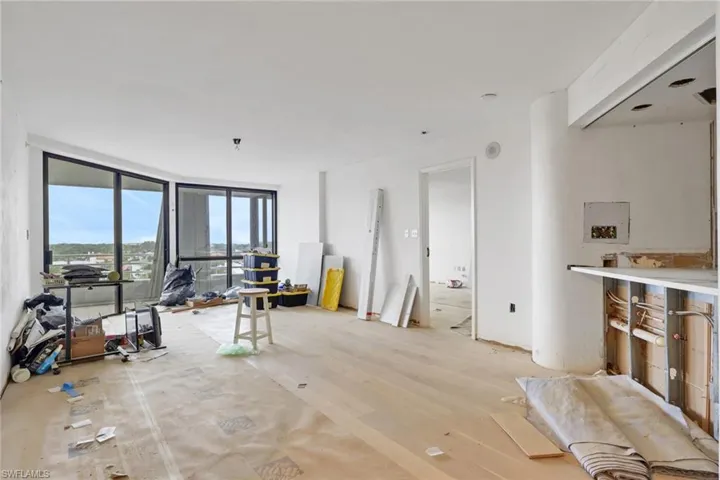 Living room featuring wood finished floors and a wall of windows