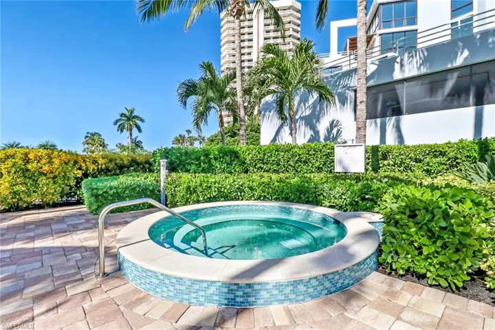 View of pool featuring a hot tub and a patio area
