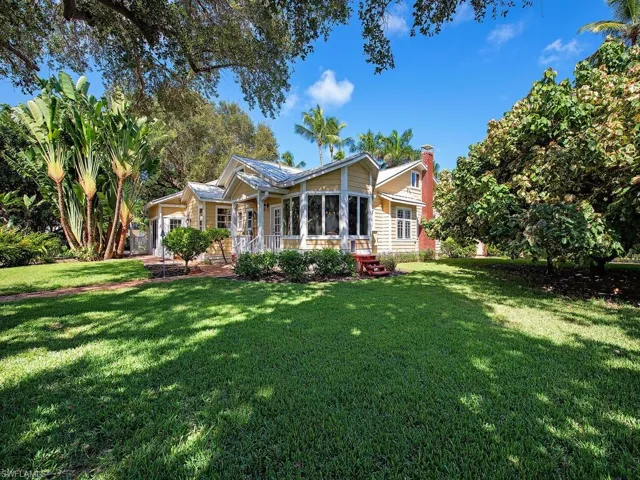 Back of property featuring a sunroom, a yard, and a chimney