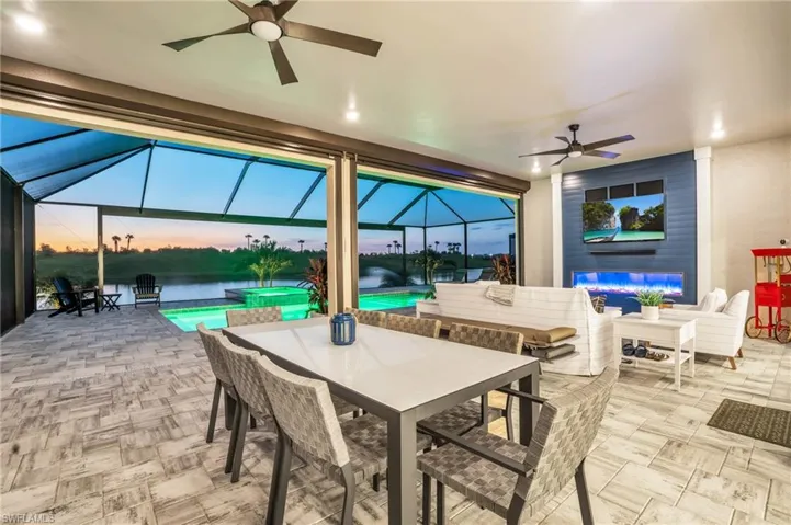 Patio terrace at dusk with a lanai and ceiling fan