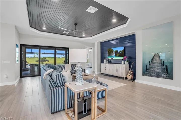 Living room featuring ceiling fan and a tray ceiling