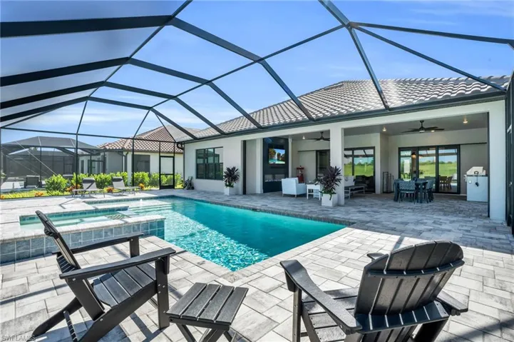 View of swimming pool with ceiling fan, an in ground hot tub, a patio, glass enclosure, and outdoor lounge area