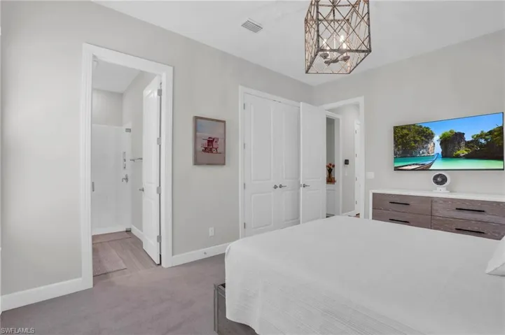 Carpeted bedroom with ensuite bath and a closet