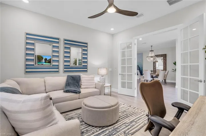 Office space featuring french doors, light wood-type flooring, and ceiling fan