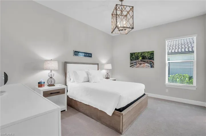 Carpeted bedroom featuring a notable chandelier