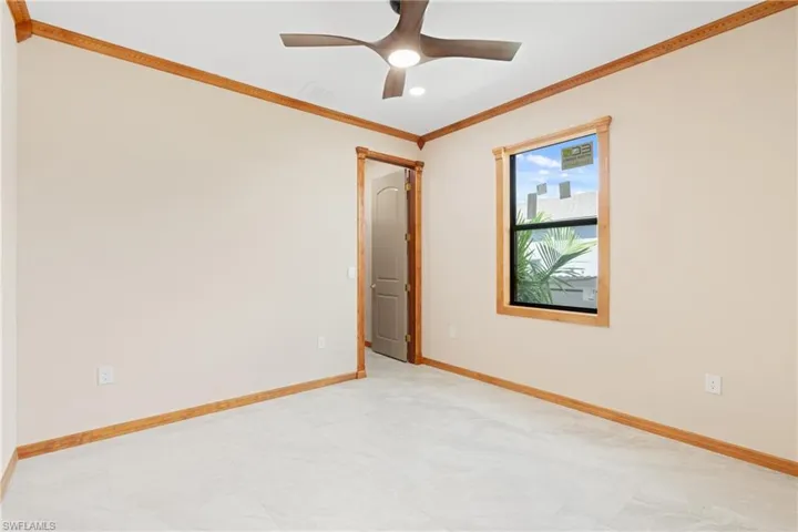 Tiled spare room featuring crown molding and ceiling fan