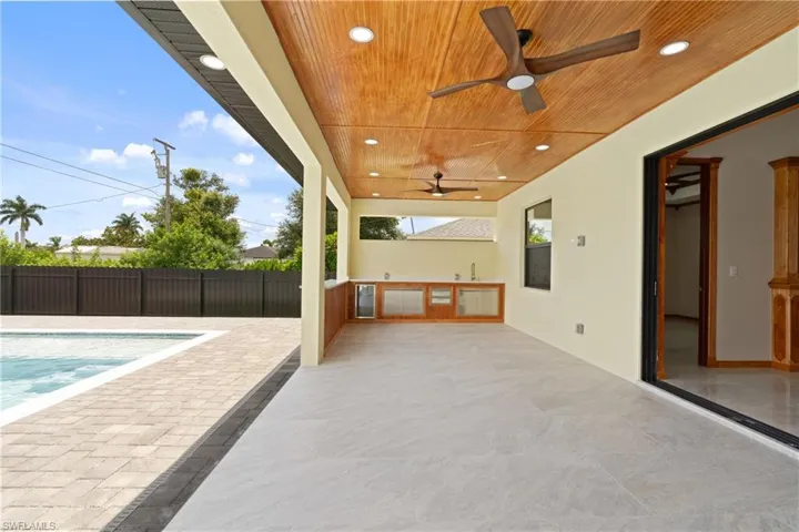 View of patio featuring ceiling fan and a fenced in pool