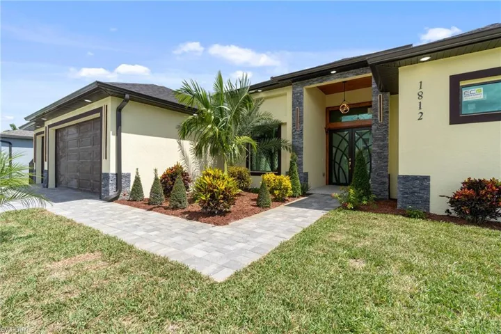 View of front of house featuring a garage and a front yard