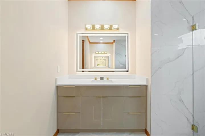 Bathroom with ornamental molding, vanity, and tile patterned flooring